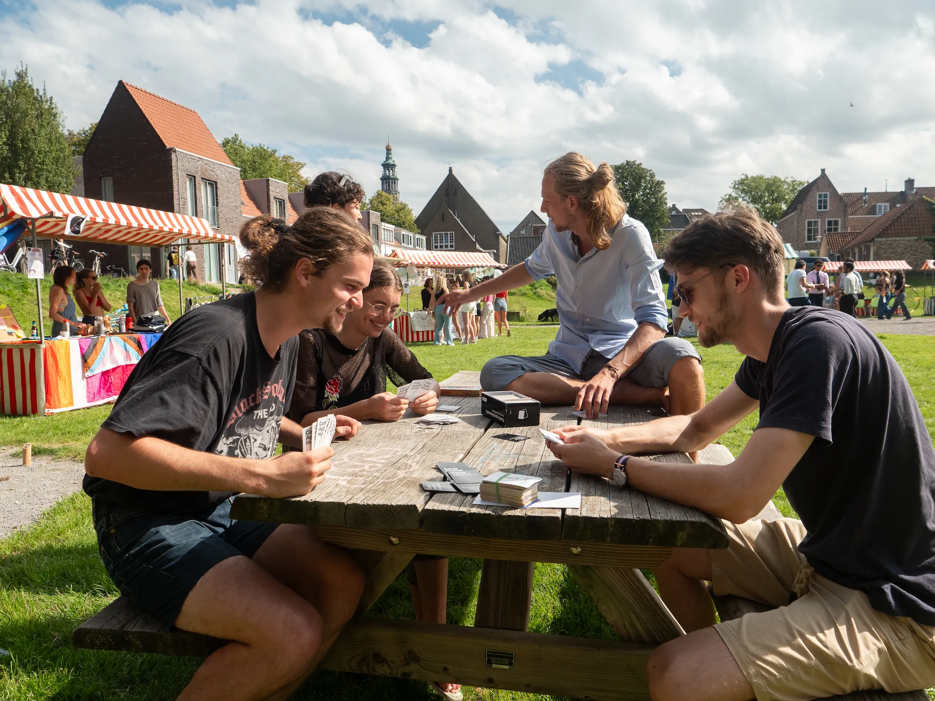 Students sitting at a table outside playing card games