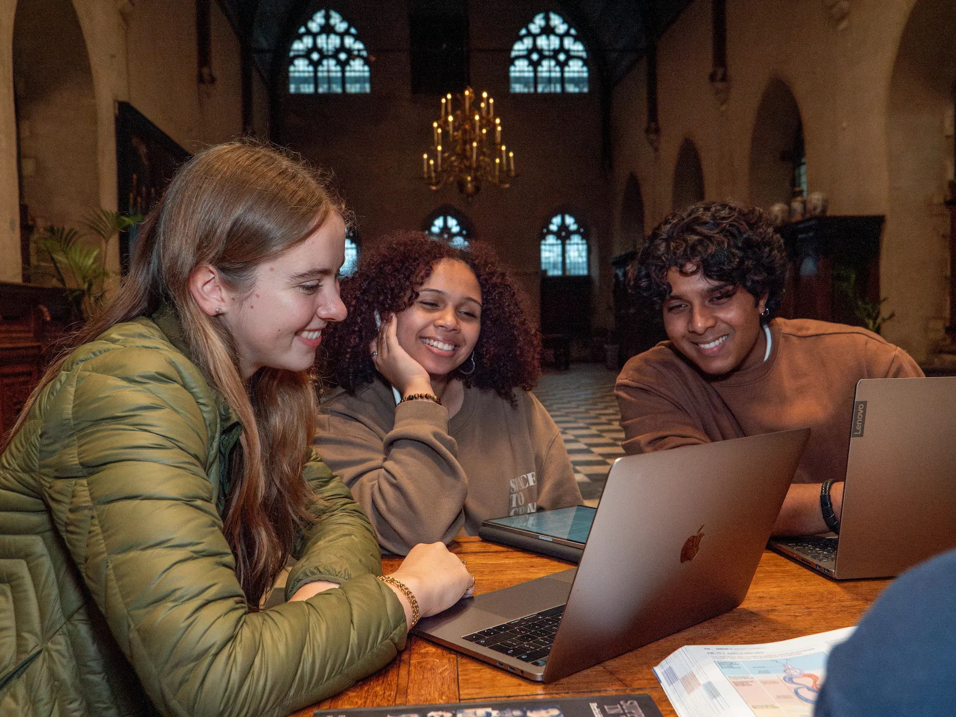 College students sitting smiling at a laptop
